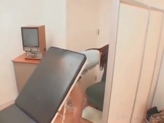 Ázijské pacient kurvička opened s lekárske zrkadlo na the therapist